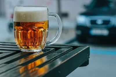 Jarra de cerveza con espuma sobre una mesa de madera