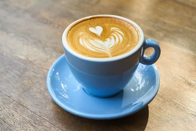Café con leche en una taza azul sobre un plato